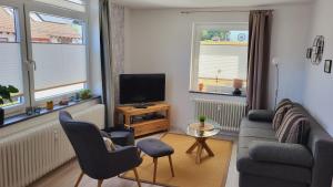 a living room with a couch and a tv at Ferienwohnung Hoch im Harz, Altenau in Altenau