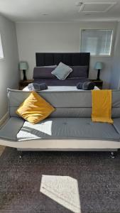 a large bed with yellow pillows on it in a room at Self contained studio apartment close to Mission Estate in Napier