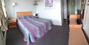 Un dormitorio con una cama con una manta de colores. en Chimo Motel, en Cochrane