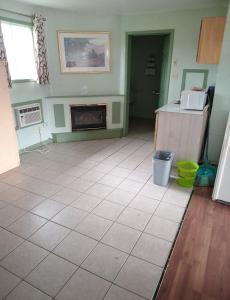 a living room with a tile floor and a fireplace at Chimo Motel in Cochrane