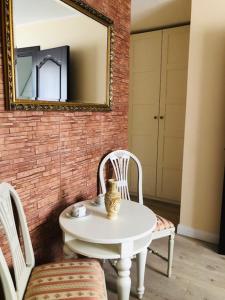 a white table with two chairs and a mirror at Columba Livia Guesthouse in Palanga