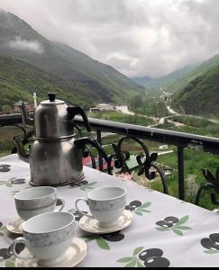 a tea kettle and cups on a table with a view at Sümela Monastery & Hamsikoy Apart Hotel in Trabzon