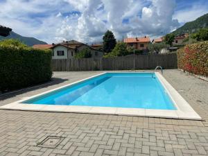 a blue swimming pool in a yard with a fence at Casa Manzoni in Lenno