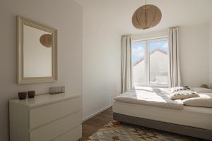 ein weißes Schlafzimmer mit einem Bett und einem Fenster in der Unterkunft Beach Loft Stein in Stein