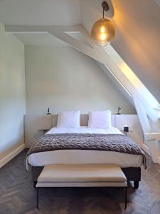 een slaapkamer met een groot bed op zolder bij Hotel Bloemendaal in Bloemendaal