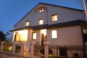 a white house with a fence in front of it at Brand new LUX Apartment in Skopje