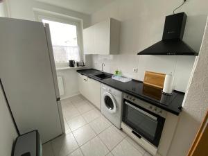 a kitchen with a washing machine and a window at Neue Ferien Monteurwohnung mit 3 Schlafzimmer 22 in Wefensleben +3 photos