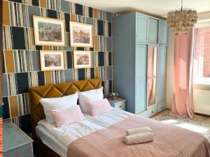ein Schlafzimmer mit einem großen Bett mit rosa Kissen in der Unterkunft Apartament Starogdański Nad Motławą in Danzig