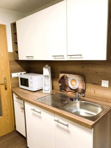 a kitchen with a sink and a microwave at Ferienwohnung Schickolores in Eibenstock