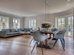 Una sala de estar con una mesa y sillas y un sofá. en Haus Riva, en Wenningstedt