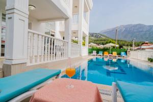 a hotel swimming pool with a drink on a table at Villa Angel - Private Pool and Nature View in Ölüdeniz in Fethiye