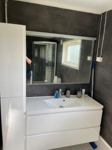 Un baño con un lavabo blanco y un espejo. en Sunny House, en Bud