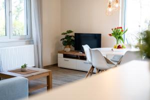 a living room with a white table and a television at Strandhaus 1 EG in Marienfelde