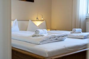 two beds in a room with white sheets and towels at Strandhaus 1 EG in Marienfelde