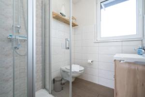 a bathroom with a toilet and a glass shower at Strandhaus 1 EG in Marienfelde +22 photos