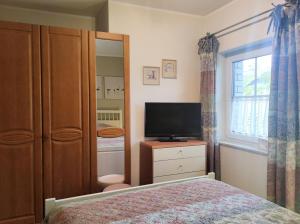 1 dormitorio con cama y vestidor con TV en F-1064 Rhododendronbluete in Lietzow, en Lietzow