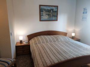 Un dormitorio con una cama con dos mesitas de noche y dos lámparas. en F-1064 Rhododendronbluete in Lietzow, en Lietzow