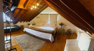 - une chambre mansardée avec un grand lit dans l'établissement Hotel Casa Madero, à Envigado