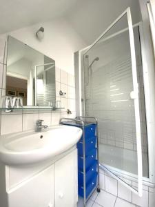 a white bathroom with a sink and a shower at An de Bäk Bornstübchen in Born