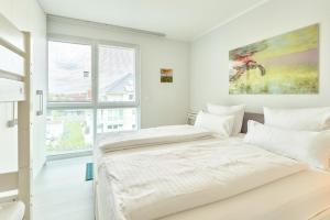 Duas camas num quarto branco com uma janela em SeeVilla Scharbeutz em Scharbeutz