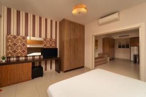 a bedroom with a bed and a television in it at Tsokas Hotel in Finikounta