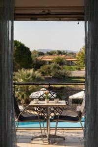 a table and chairs on a balcony with a view at Tsokas Hotel in Finikounta