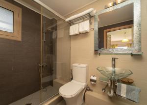 a bathroom with a toilet and a glass sink at Tsokas Hotel in Finikounta