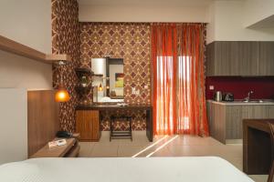a room with a kitchen with a bed and a mirror at Tsokas Hotel in Finikounta
