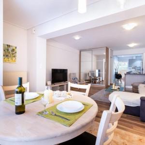 ein Wohnzimmer mit einem Tisch und einer Flasche Wein in der Unterkunft Alimos Bright Apartment near the Beach in Athen