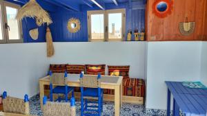 Habitación con mesa, sillas y cama en Riad Al Manara en Esauira