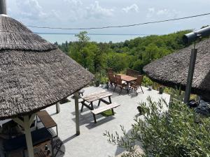 een patio met een tafel en stoelen en een dak bij Panorama Apartmanház in Badacsonytomaj