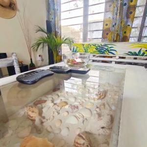 een glazen tafel met schelpen en een toetsenbord erop bij Palm Paradise Loft in Diani Beach