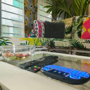 dois controlos remotos sentados numa mesa ao lado de um sofá em Palm Paradise Loft em Praia de Diani