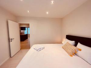 Schlafzimmer mit einem großen weißen Bett und einer Tür in der Unterkunft Cosy Of John Cockerill in Seraing