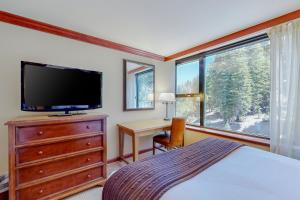 Dormitorio con cama, escritorio y TV en Resort at Squaw Creek's 605, en Olympic Valley