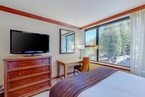 a bedroom with a bed and a desk and a television at Resort at Squaw Creek's 605 in Olympic Valley