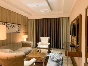 een woonkamer met een bank en een stoel bij Midan Hotel & Suites Al Aziziya in Mekka