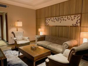 a living room with a couch and two chairs at Midan Hotel & Suites Al Aziziya in Makkah
