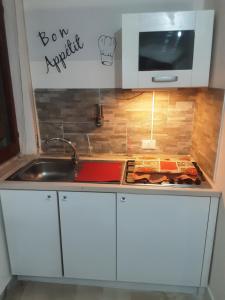 a kitchen counter with a sink and a microwave at Affittacamere da chris in Reggio Calabria