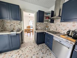 a kitchen with blue cabinets and a sink at Charmante Maison au centre-ville in Pornic +8 photos