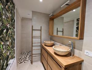a bathroom with two sinks on a wooden counter at Charmante Maison au centre-ville in Pornic