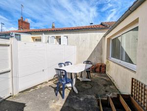 a patio with a table and chairs and a fence at Charmante Maison au centre-ville in Pornic