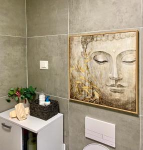 スコピエにあるMoon Loft next to East Gate Mall Free Parking includedの壁面の絵画が飾られたバスルーム