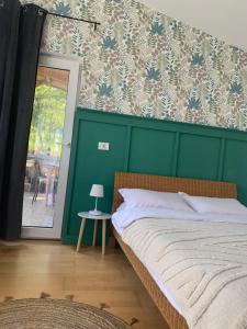 1 dormitorio con 1 cama con pared verde en Backyard Cottage, 