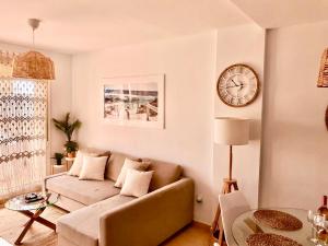 sala de estar con sofá y reloj en la pared en La Isla Casa de Franco - Condado De Alhama Golf Course en Alhama de Murcia