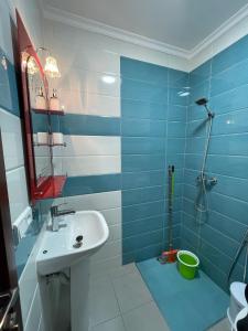 ein blau-weißes Bad mit einem Waschbecken und einer Dusche in der Unterkunft Tangier house in Tangier