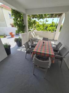 een patio met een tafel en stoelen bij 6 M, 50 m do plaže in Barbat na Rabu