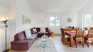 a living room with a couch and a table at Feriendorf Südstrand Haus 23 in Pelzerhaken