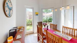 a dining room with a table and a clock on the wall at Feriendorf Südstrand Haus 23 in Pelzerhaken +33 photos