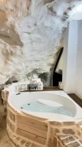 a bathroom with a bath tub in a stone wall at Cave house in Heraklio